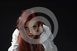 Portrait of beautiful redhead young woman in trouble looking at the camera