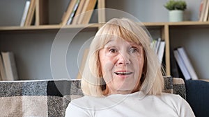 Portrait of a beautiful retired woman sitting and smiling at the camera.