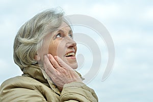 Beautiful senior woman against blue sky