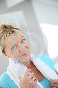 Portrait of beautiful senior woman drinking water after excercising