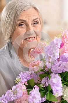 Portrait of beautiful senior woman posing with flowers