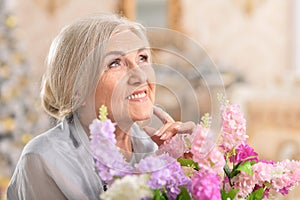 Portrait of beautiful senior woman posing with flowers