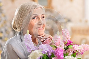 Portrait of beautiful senior woman posing with flowers