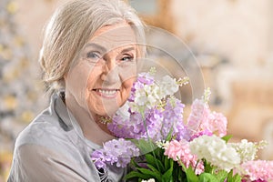 Portrait of beautiful senior woman posing with flowers