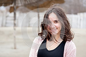 Portrait of beautiful sensitive young girl or woman posing outdoors in casual clothes with smile and adorable eyes