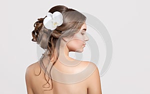 Portrait of a beautiful sensual light brown haired woman with a wedding hairstyle and nude make-up in a beauty salon. In the hair