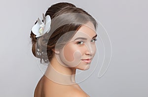 Portrait of a beautiful sensual light brown haired woman with a wedding hairstyle and nude make-up in a beauty salon. In the hair