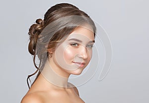 Portrait of a beautiful sensual light brown haired woman with a wedding hairstyle and nude make-up in a beauty salon.Wedding