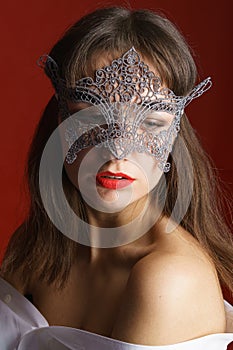 Portrait beautiful sensual woman in black lace mask on red background. Sexy