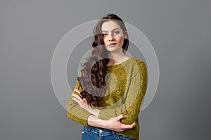 Portrait of beautiful sensual woman with long curly hair against gray background