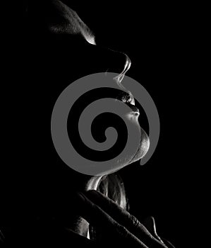Portrait of beautiful sensuality pensive girl profile with closed eyes in a dark, on a black background
