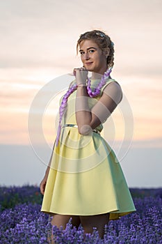 Portrait of a beautiful and sexy girl with long braids in a lavender field. Sunset in the background