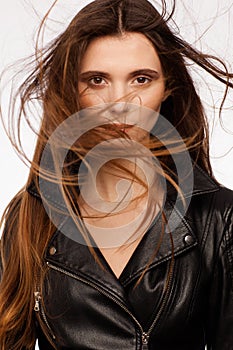 Portrait of a beautiful sexy model in black leather jacket. Hair in the wind