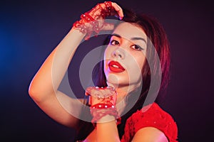 Portrait of beautiful traditional oriental belly dancer girl dancing on blue neon smoky background. Woman in red