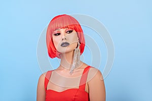 Portrait of beautiful sexy woman in red wig Bob hairstyle. Long earring