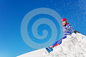 Portrait of a beautiful ski girl sit on snow pile