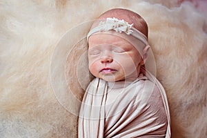 Portrait of a beautiful sleeping newborn girl with a bandage on his head