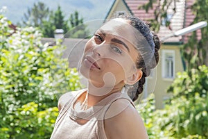 Portrait of a beautiful slender woman 25-30 years old against the background of a summer country house.