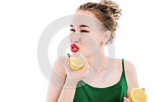 Portrait of a beautiful, slim, young girl who eats a lemon.