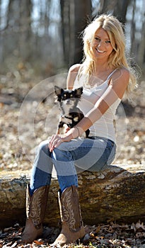 Portrait of a beautiful smiling blonde woman and her small dog