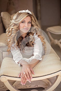 Portrait of beautiful smiling bride with long curly hair posing