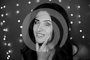 Portrait of a beautiful smiling brunette with long hair. Perky. Studio photography , bokeh light bulbs. Black and white