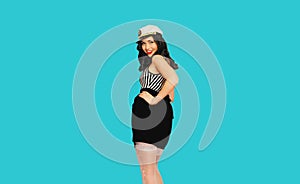 Portrait of beautiful smiling brunette woman in pin up style wearing sailor costume  on blue background