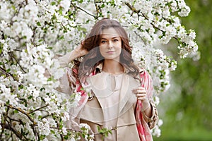 Portrait of a beautiful smiling brunette young women  in blossom apple tree garden in spring time. Enjoy Nature. Healthy girl