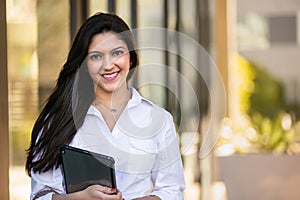 Portrait of a beautiful smiling cheerful female indian american successful business woman CEO entrepreneur at the workplace, stand