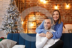 Portrait of beautiful smiling couple hugging at Christmas eve. Beautiful young couple at home enjoying spending time