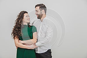 Portrait of beautiful smiling couple posing at studio over white background.