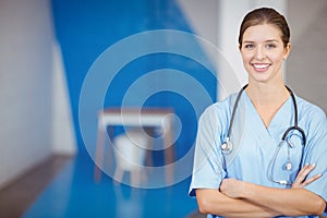 Portrait of beautiful smiling female doctor with arms crossed