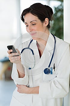 portrait beautiful smiling female doctor holding mobile phone