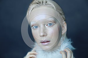 Portrait of a beautiful girl in the frost on his face on a blue ice background