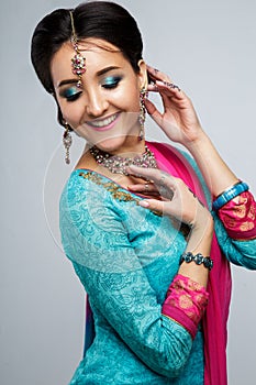 Portrait of beautiful smiling indian girl. Young indian woman model with traditional jewelry set