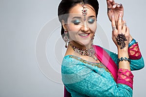 Portrait of beautiful smiling indian girl. Young indian woman model with traditional jewelry set