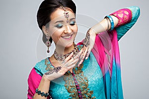 Portrait of beautiful smiling indian girl. Young indian woman model with traditional jewelry set