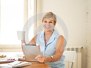 Portrait of a happy senior woman using electronic tablet at home