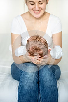 Portrait of beautiful smiling mother holding her baby`s head