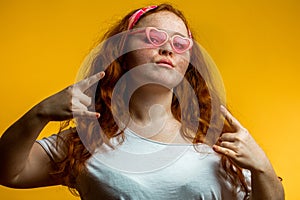 Portrait of beautiful smiling redhead girl wearing big pink glasses