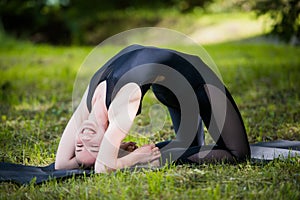 Portrait of beautiful smiling sporty fit blond young woman doing bikram yoga backbend on summer day, Natarajasana, full photo