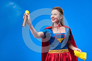 portrait of beautiful smiling superwoman with rag and detergent for cleaning