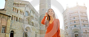 Portrait of beautiful smiling tourist woman in Parma with Cathedral, Bell tower and Baptistery. Panoramic view of traveler girl