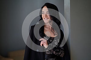 Portrait of beautiful smiling woman with long hair in a lace dress and black jacket
