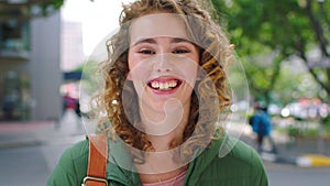 Portrait of a beautiful smiling woman looking happy outside. Face closeup of a young trendy female enjoying a walk or
