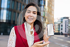 Portrait of a beautiful smiling woman professional business worker looking in camera and holding in hand mobile phone