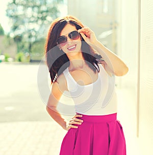 Portrait of beautiful smiling young brunette woman posing in the city