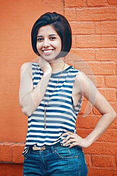 Portrait of beautiful smiling young hipster latin hispanic girl woman with short hair bob, in blue jeans, striped tshirt