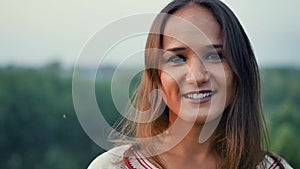 Portrait of a beautiful smiling young woman outdoors. Slow motion