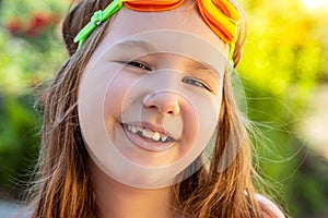 Portrait of a beautiful smilling little girl with goggles for swimming pool